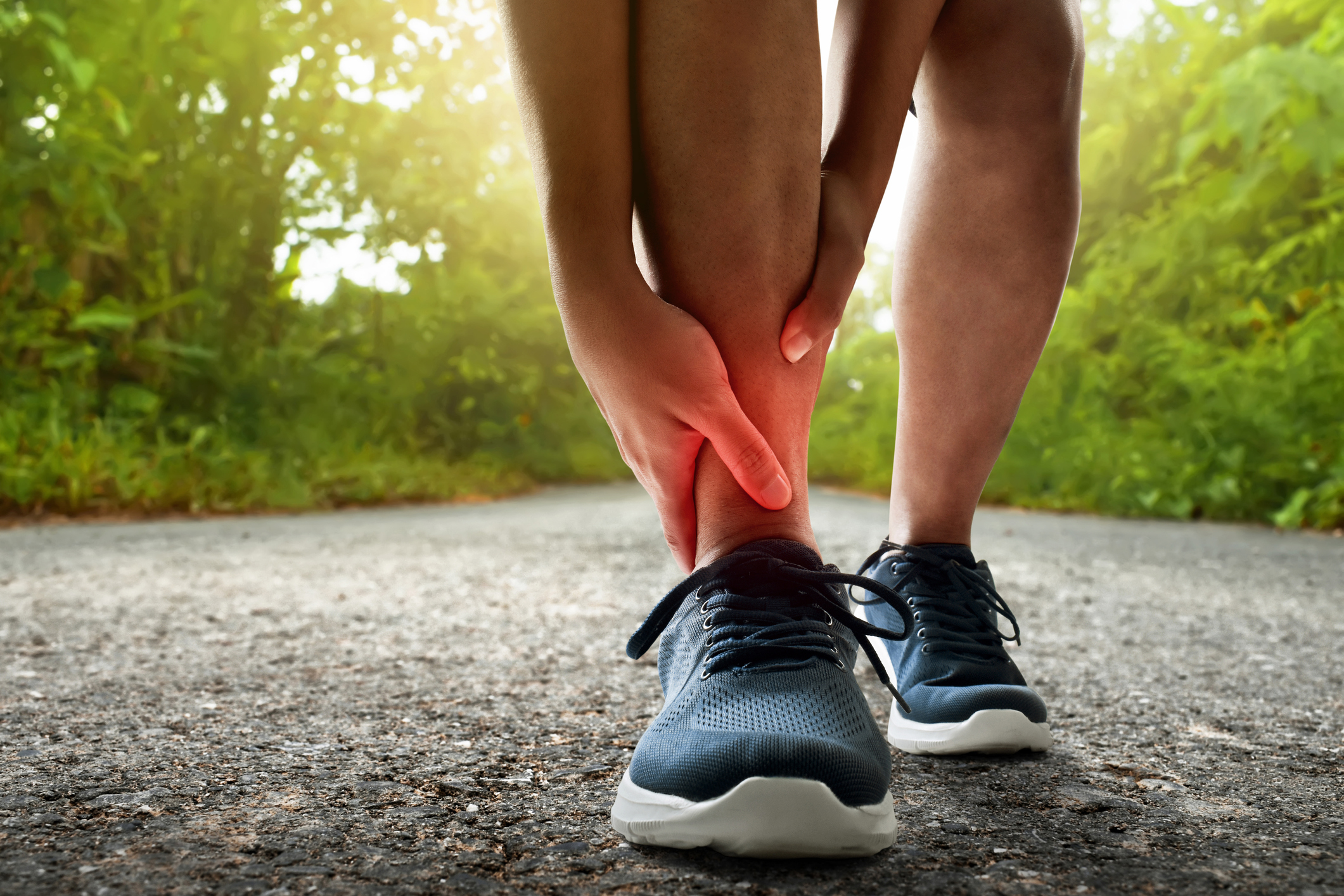 Runner stopped to hold red ankle in pain